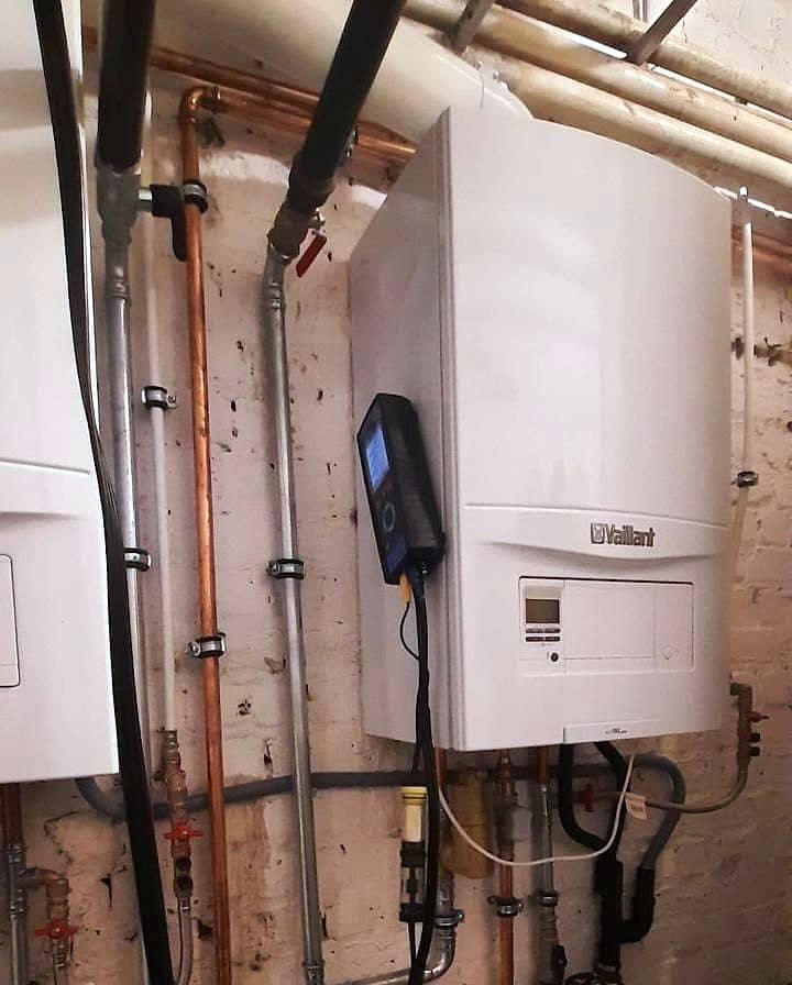 Chaudière murale Vaillant ecoTEC pro neuve avec un analyseur de combustion branché et des filtres sur les tuyaux