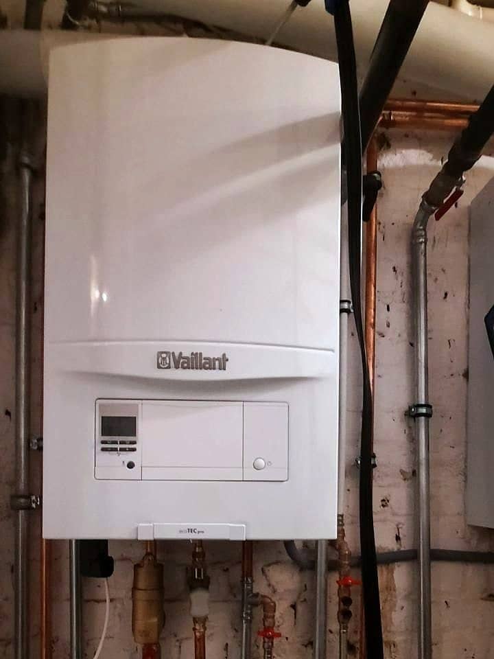 Chaudière murale à condensation Vaillant ecoTEC pro neuve, raccordée en cuivre et en acier dans une cave